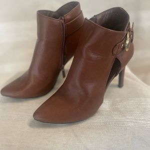 Brown heel booties with a gold buckle on side